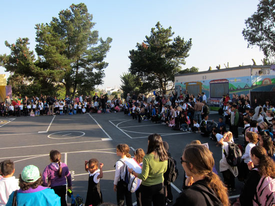 Students at Fairmount Elementary School sit to listen to morning announcements after they walked to school in a "human school bus" procession. Photo: Matthew Roth.