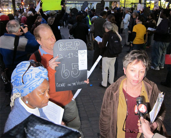 Mashasin Abdul Salaam, left, of Genesis, looks on as a coalition member is interviewed by KRON.
