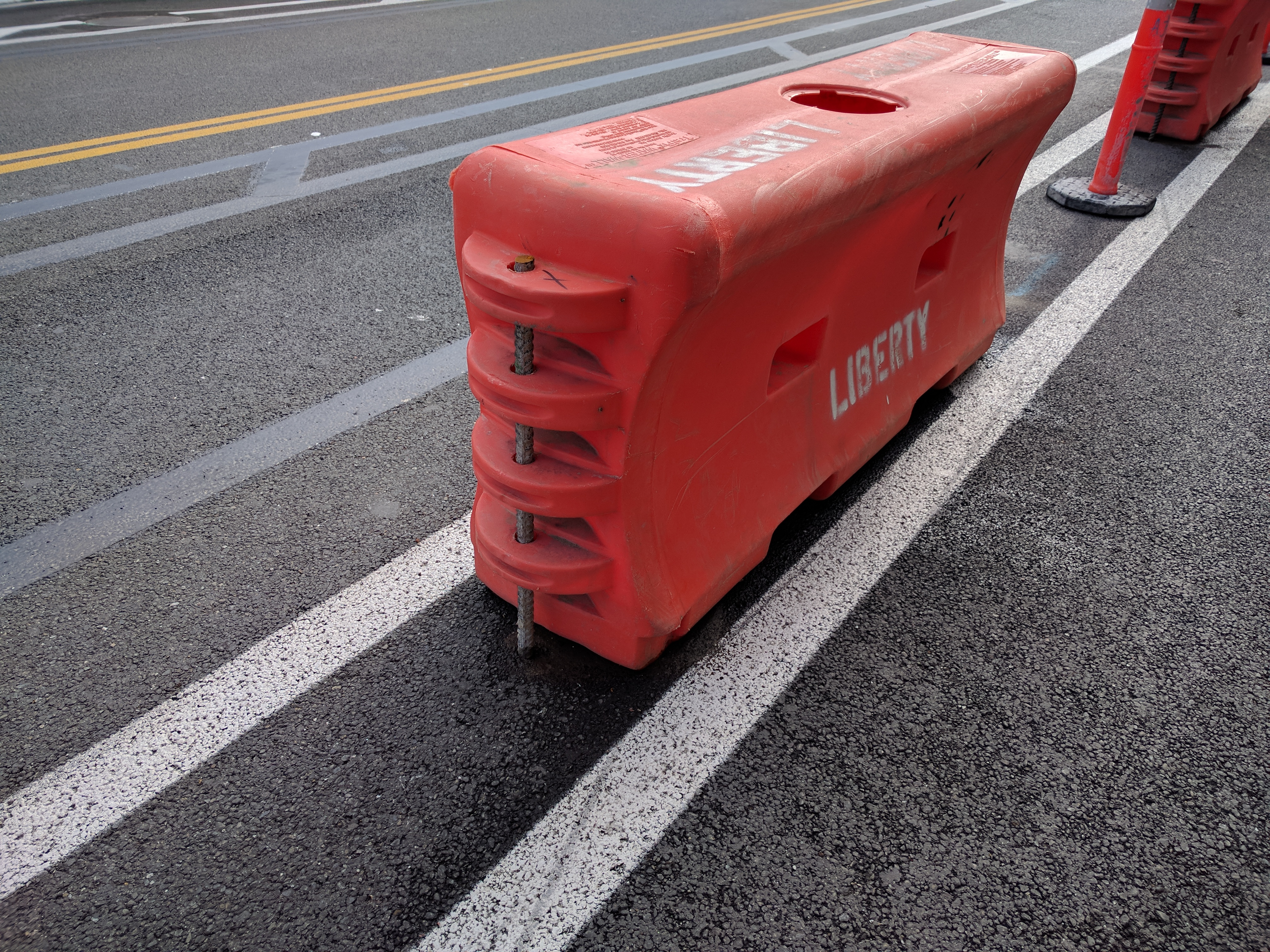 These barriers, usually filled with water or sand or gravel, are secured to the asphalt with stakes