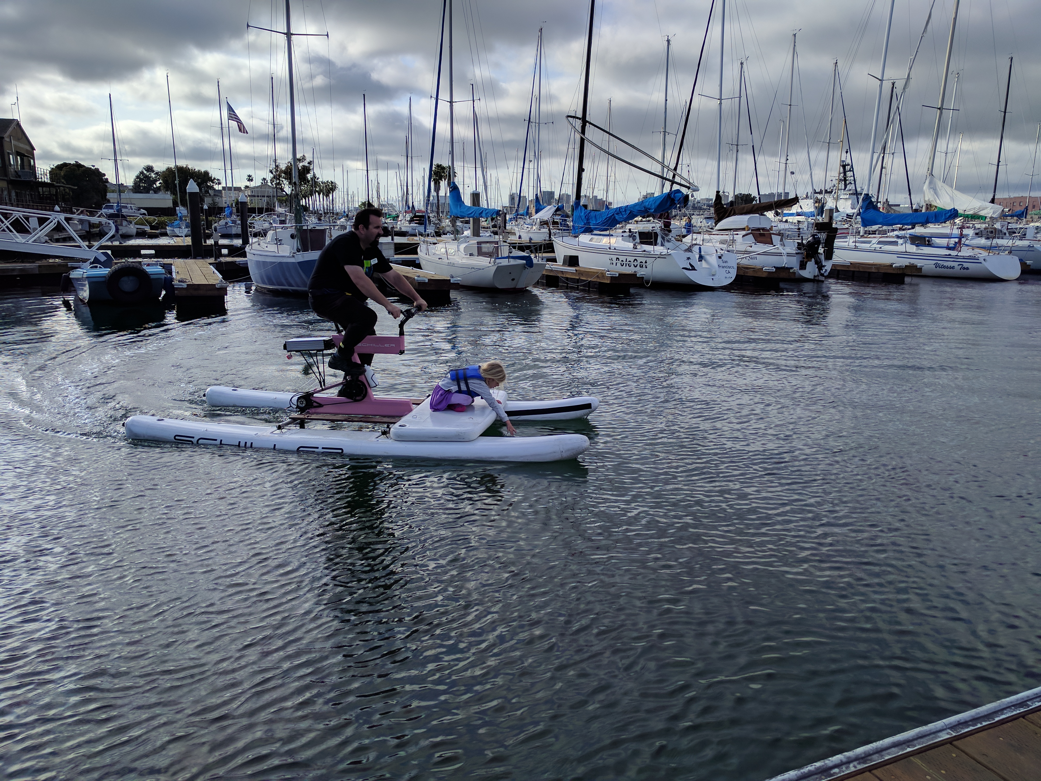 Bike Walk Alameda's Brian McGuire and his daughter trying out one of the water bikes at the Bike to Work day after party