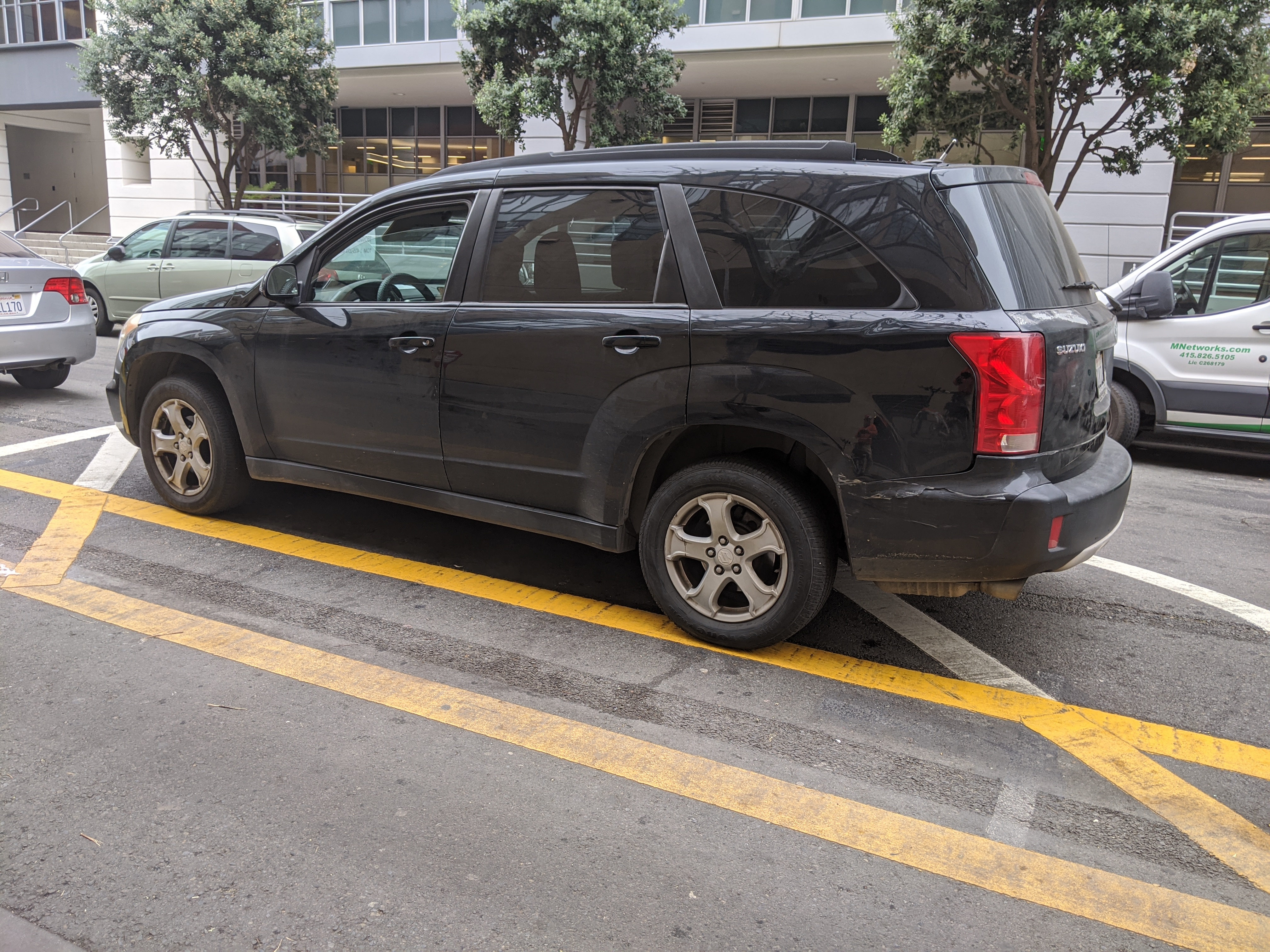 An illegally parked car blocking sightlines at a driveway on Berry. SFMTA needs more robust treatments to prevent this kind of dangerous behavior