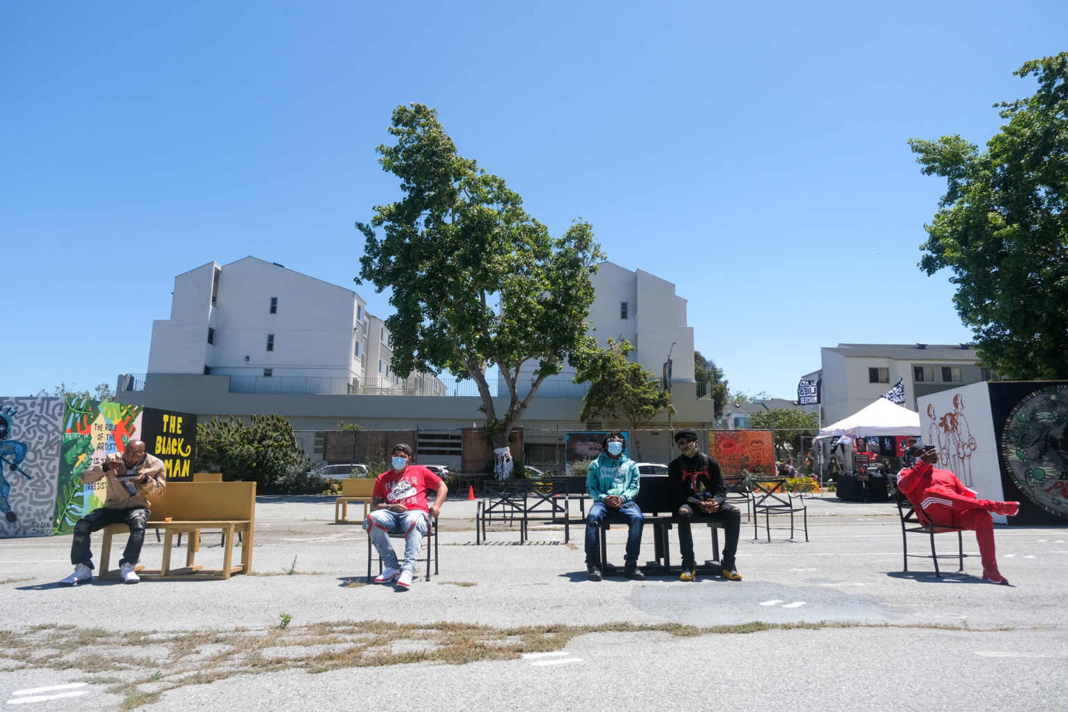 Fillmore community members relax in the open-air gallery after painting the BLM mural. | Photo by Camille Cohen