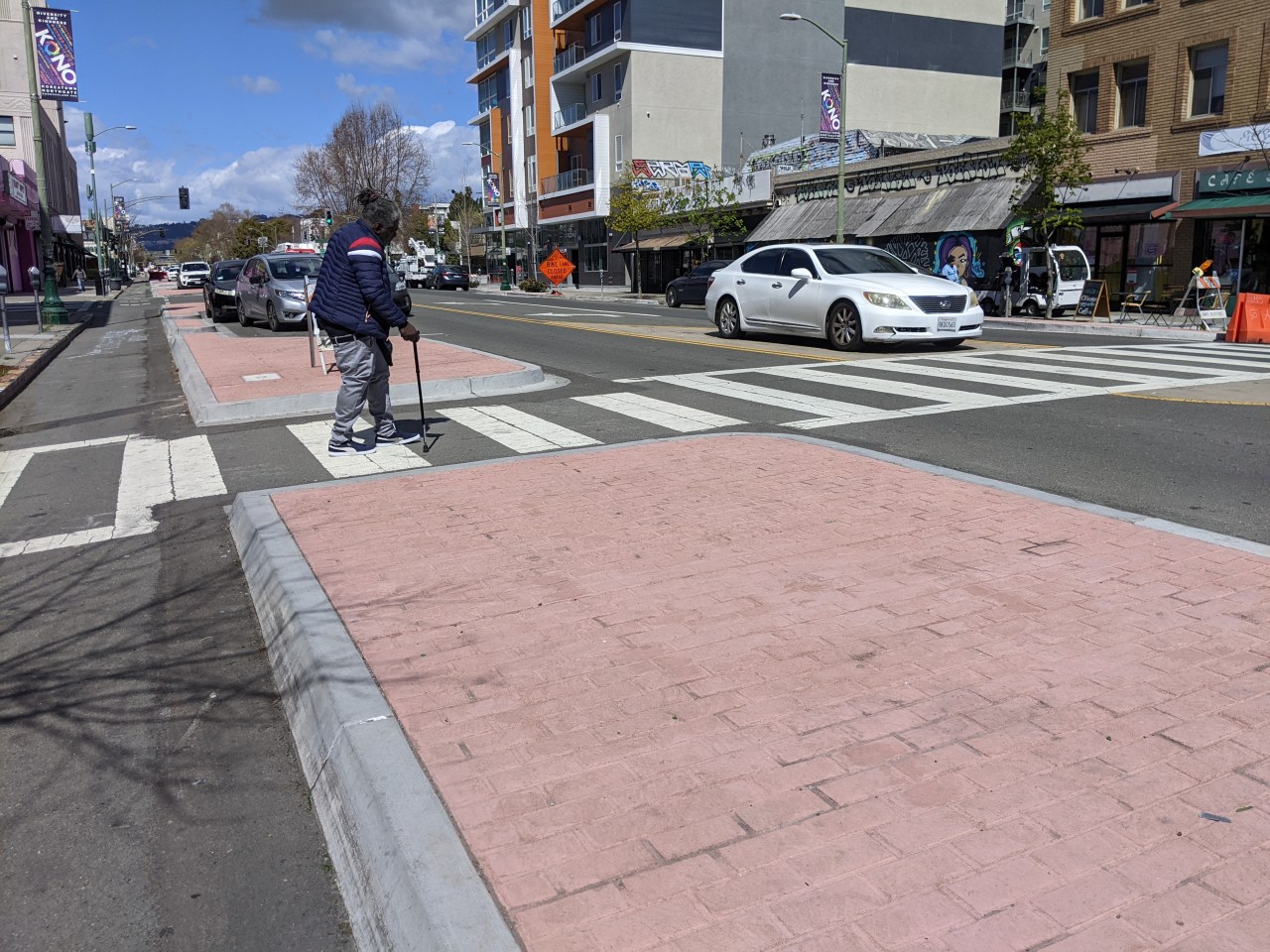 A motorist parked in the center of the street and another one double parked in the vehicle lane.